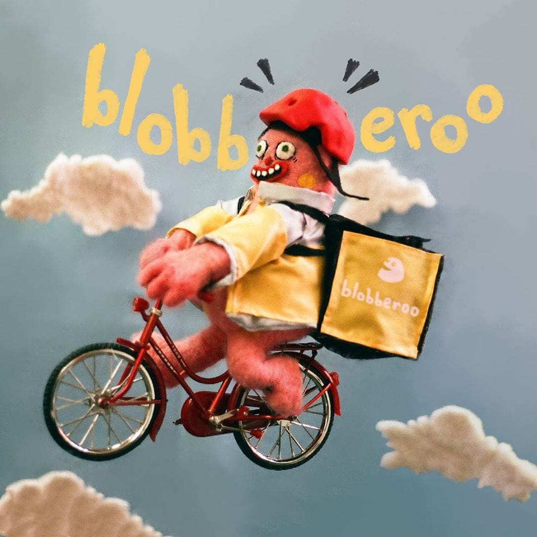 A Mr Blobby cycle courier pedals through the sky 