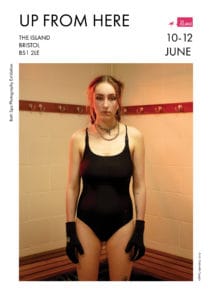Portrait of a woman wearing swimming costume and gloves in a changing room.