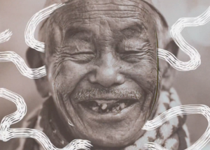 An elderly man with eyes closed and smiling to reveal a few teeth