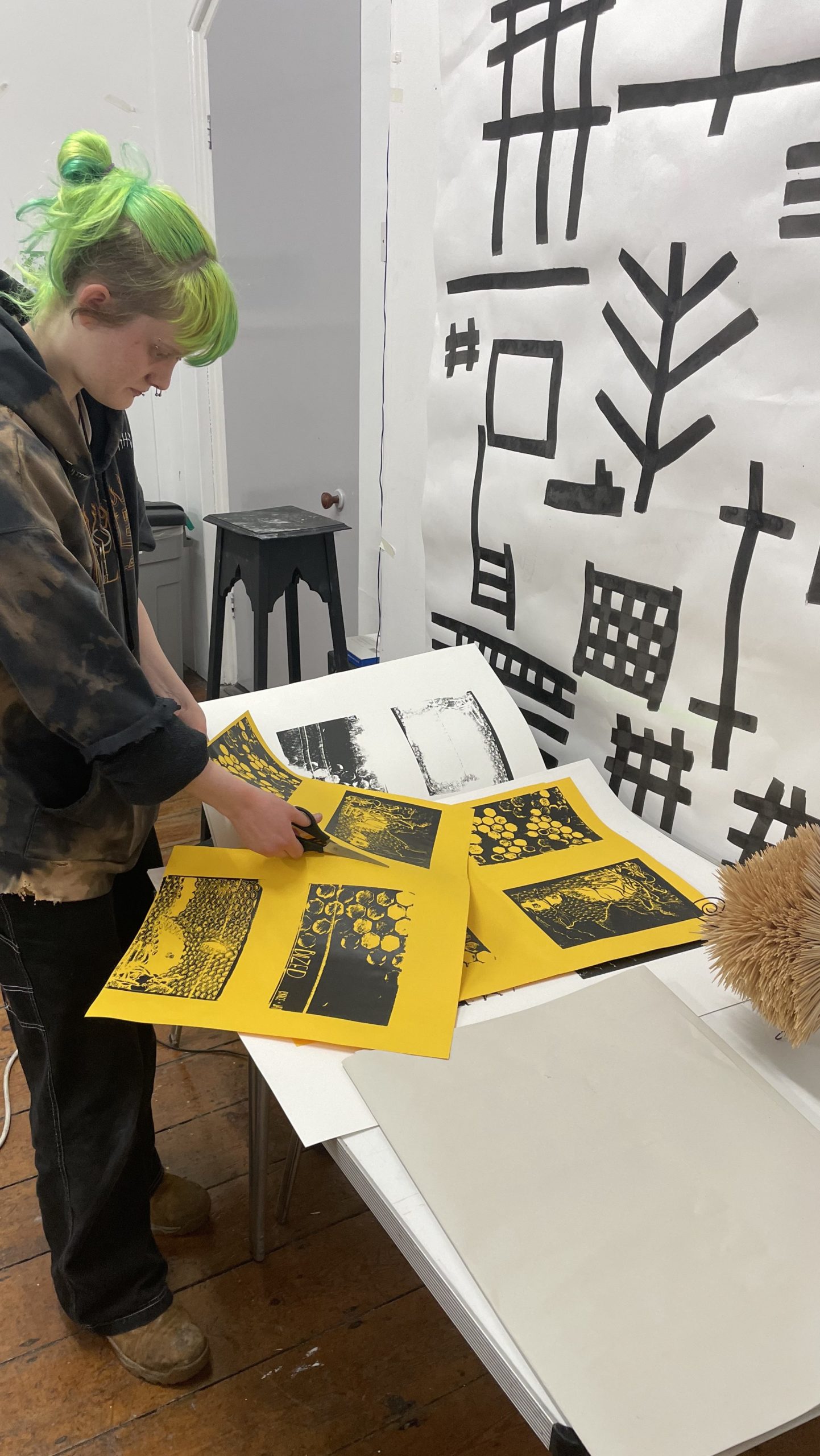 A young artist sorts through prints in their studio
