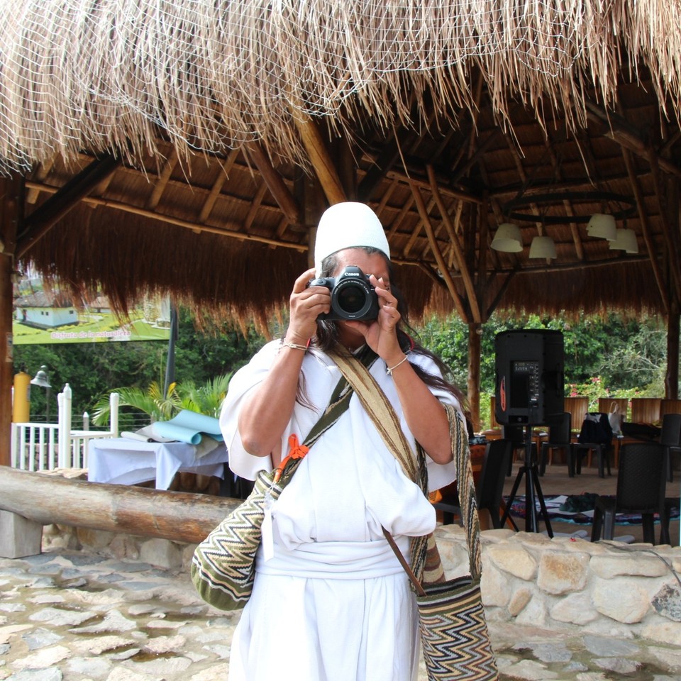 Profile of a person in a tropical setting taking a photo of the photographer