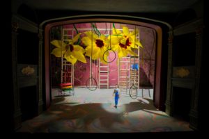 A theatre stage with outsized sunflowers and circus staging