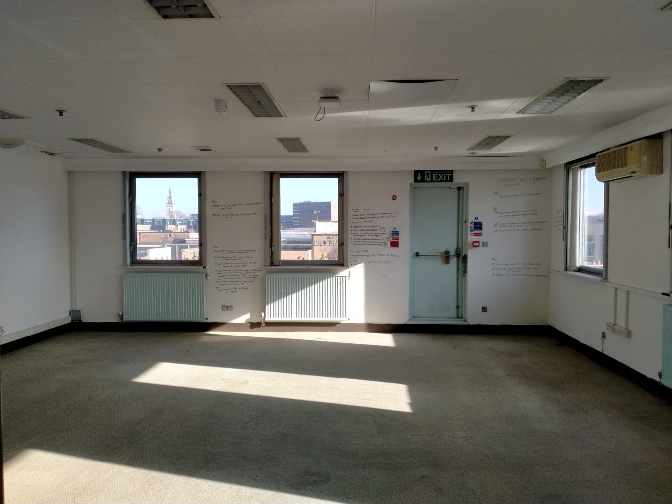 A large empty room with views over a city