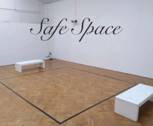 Photo of an empty gallery space with two benches and a beautifully sanded parquet floor