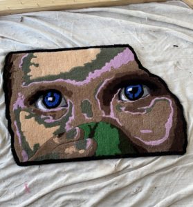 Rug art piece featuring details of a face