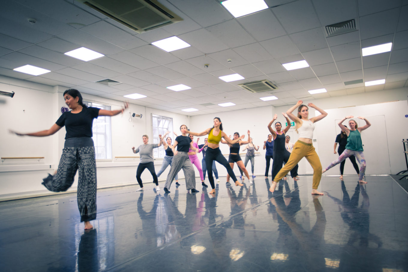 A group of dancers strike a bollywood pose in a dance studio