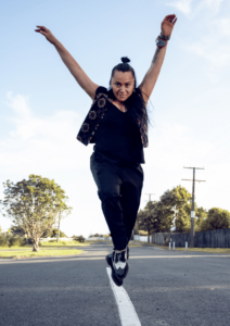 A woman jumps in the air with her hands raised