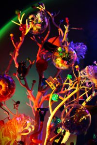 Photograph of a plastic tree supporting balls with toys inside