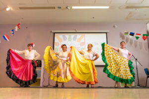 Four women wearing flamenco style dresses