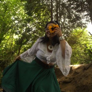 A woman in a forest smiles to