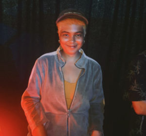 photo of a person wearing a jumpsuit in some dark woods