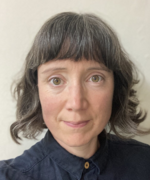 Headshot of a white woman with perfect bangs and great curls